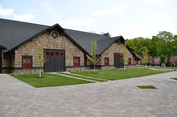 Large paver courtyard and lawn panels in front of a shake-sided commercial building
