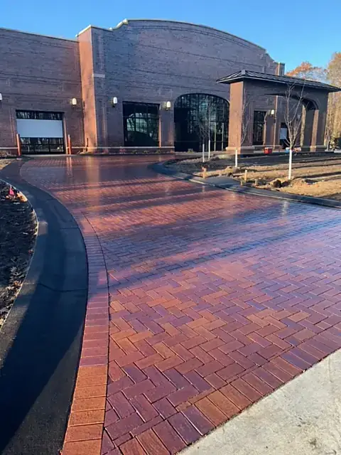 Curving red clay brick paver driveway laid in herringbone with a soldier-course border